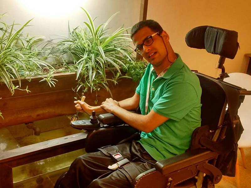 גבר בכסא גלגלים מטפל במערכת אקוופוניקה